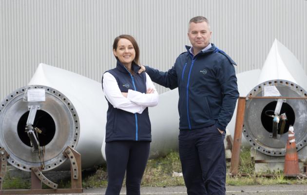 Fiona and Steven Lindsay standing in front of wind turbine blades